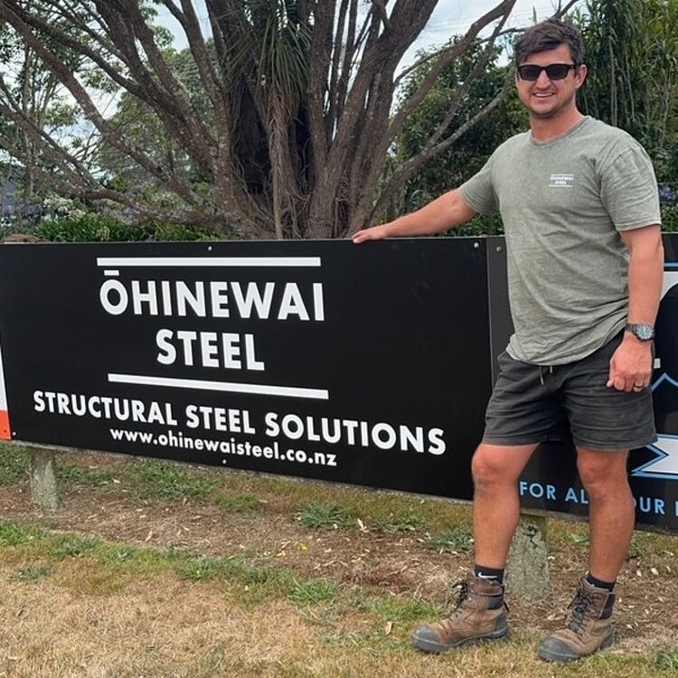 Nathan standing by Ohinewai Steel sign